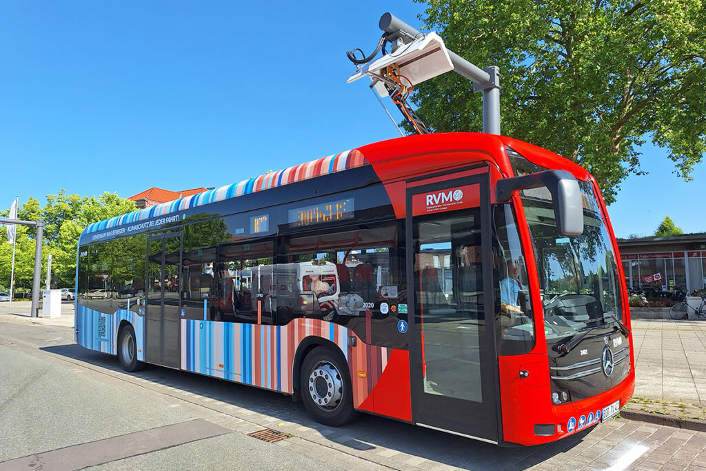 Ein Elektrobus steht unter einem Lademast.