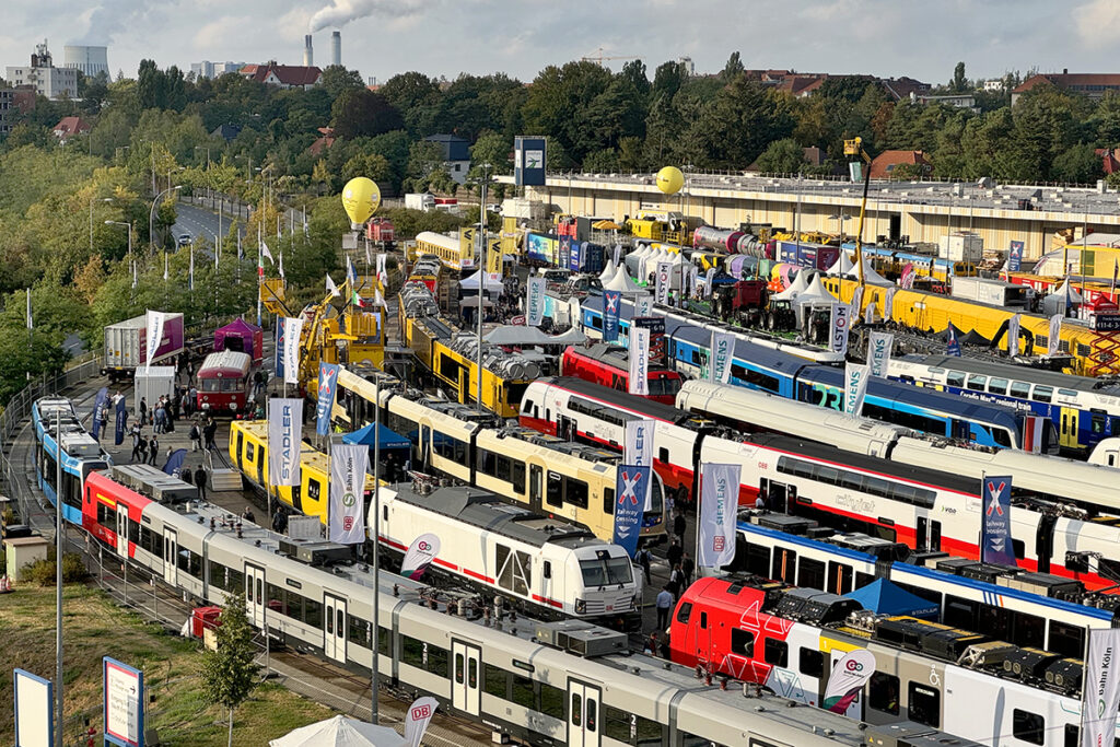 Zahlreiche Schienenfahrzeuge stehen auf einem Messegelände.