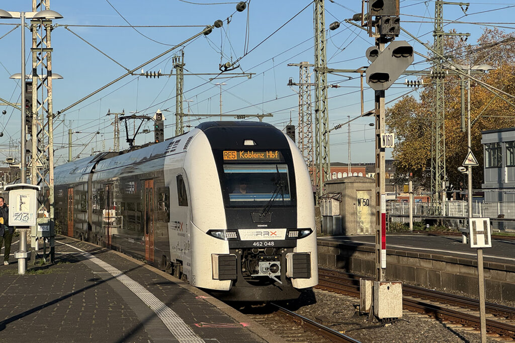 Ein Elektrotriebzug fährt an einem Bahnsteig ein.
