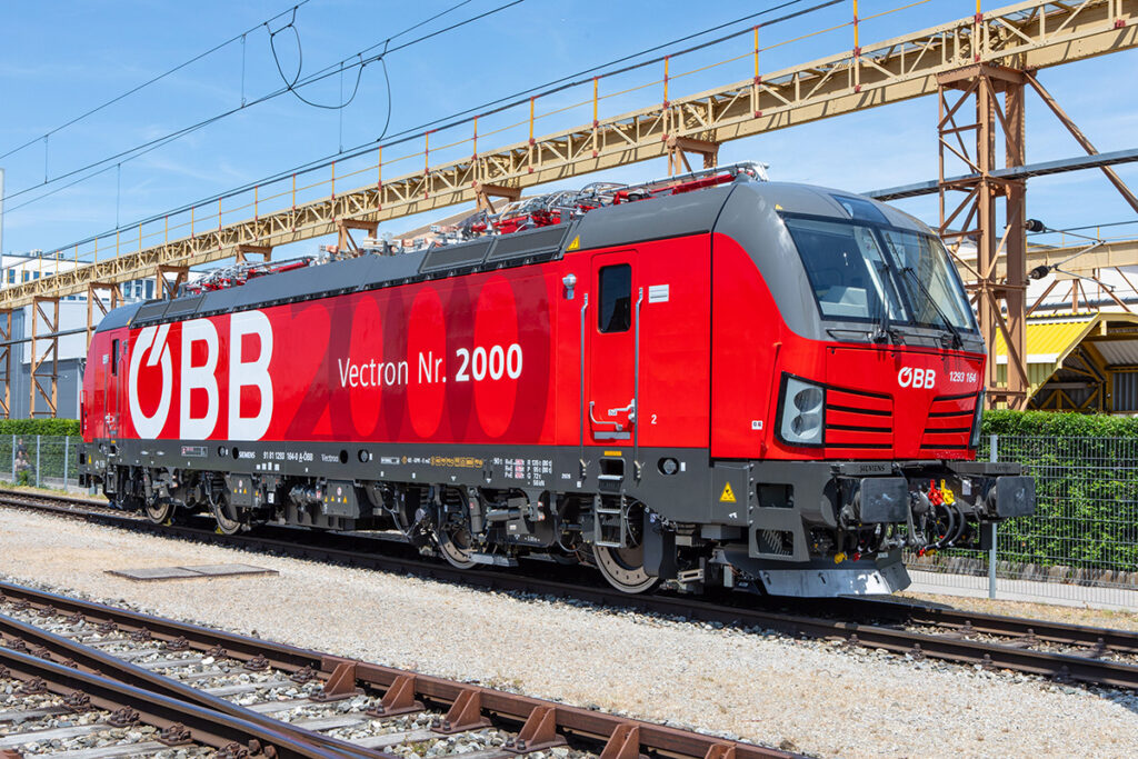 Eine Elektrolok mit der Aufschrift Vectron Nummer 2000 steht auf einem Gleis.