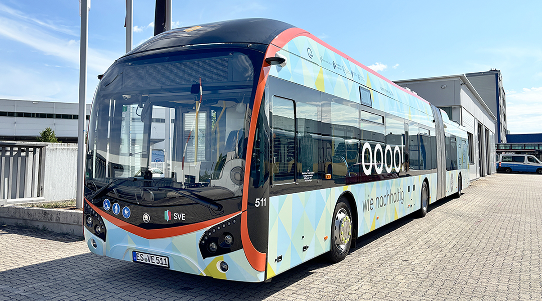 Ein Oberleitungsbus steht vor einer Halle.