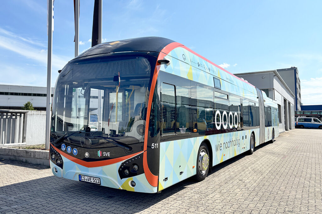 Ein Oberleitungsbus steht vor einer Halle.