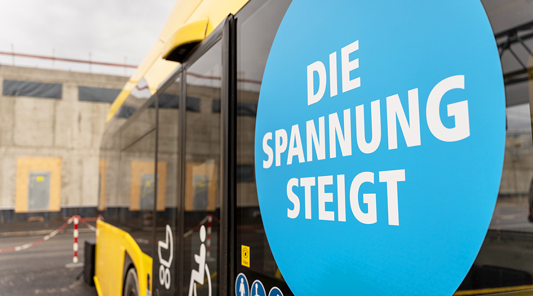 Auf einem Elektrobus steht der Schriftzug "Die Spannung steigt".