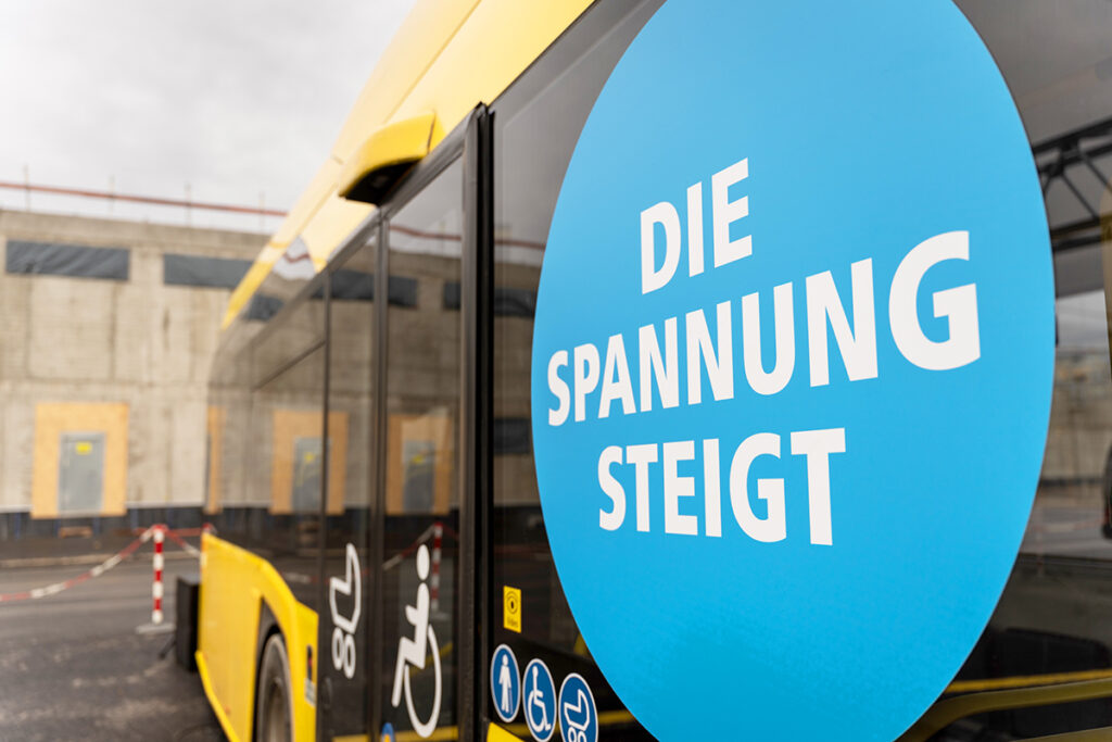 Auf einem Elektrobus steht der Schriftzug "Die Spannung steigt".