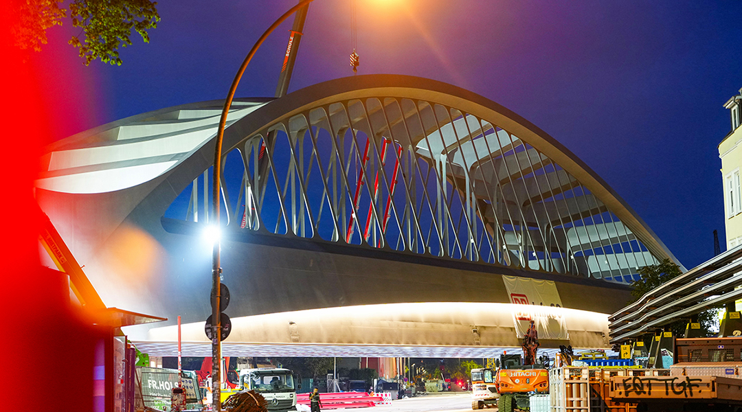 Eine Bogenbrücke in der Nacht, die angestrahtl wird.