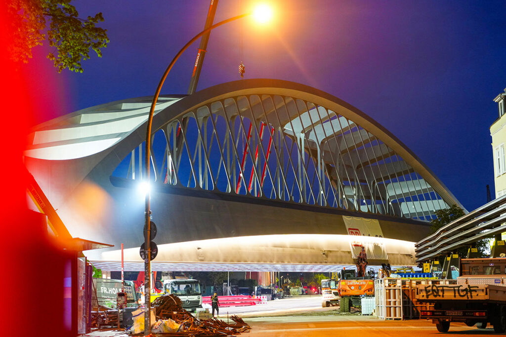 Eine Bogenbrücke bei Nacht, die angestrahlt wird.