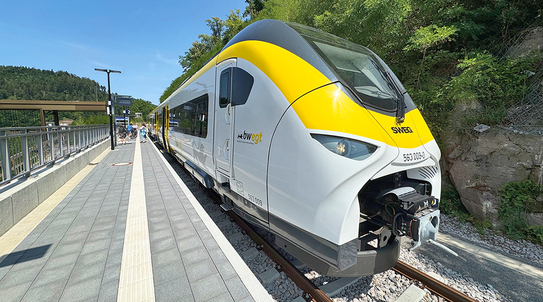 Ein Triebzug steht an einem Bahnsteig.