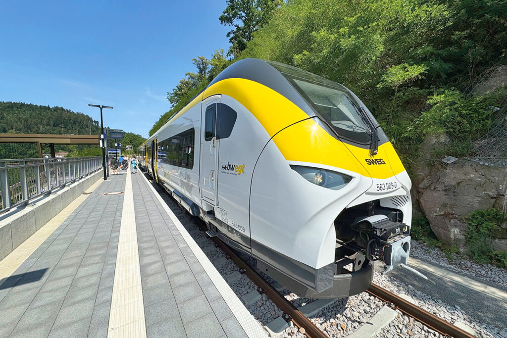 Ein Triebzug steht an einem Bahnsteig.