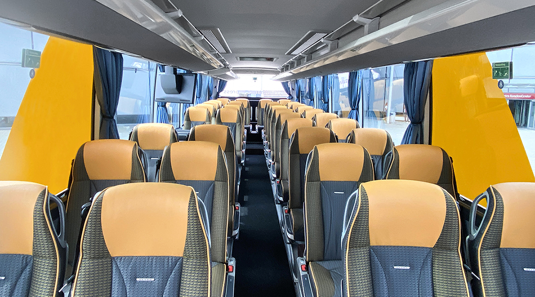 Blick in den Innenraum eines Busses mit vielen Sitzen.