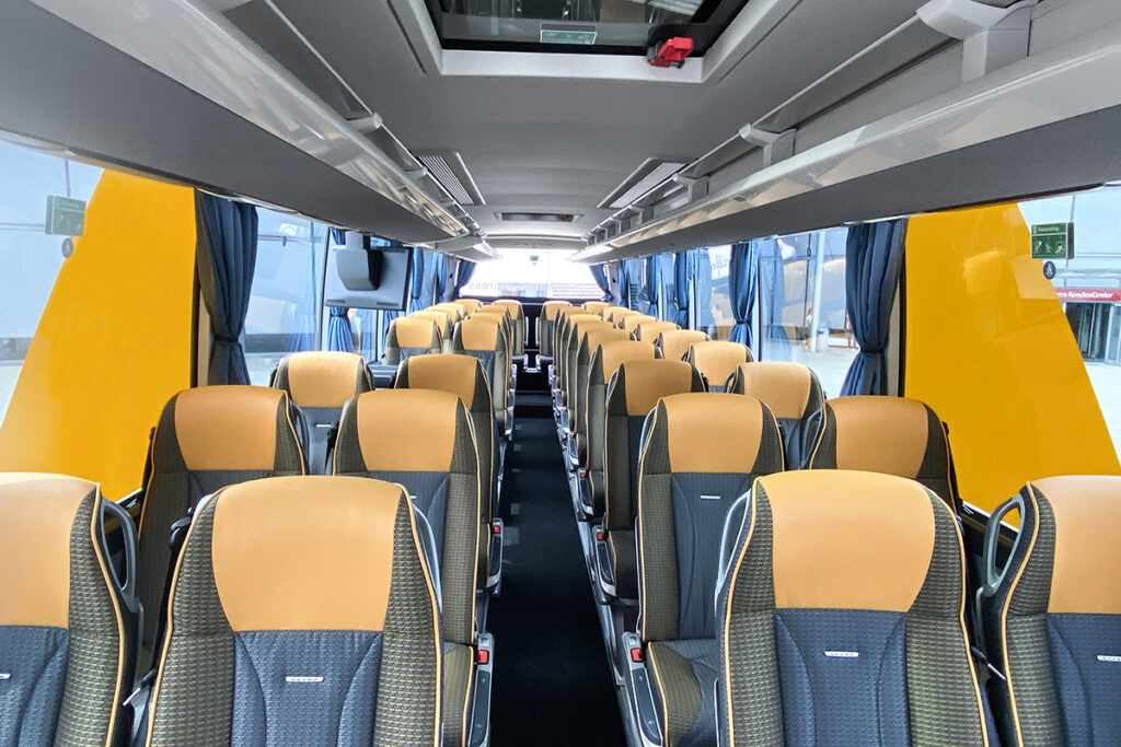 Blick in den Innenraum eines Busses mit vielen Sitzen.