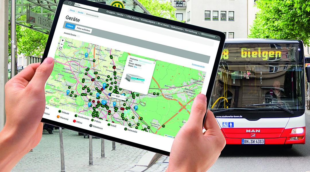 Ein Tablet mit einer Karte wird vor einem Bus im Hintergrund gehalten.