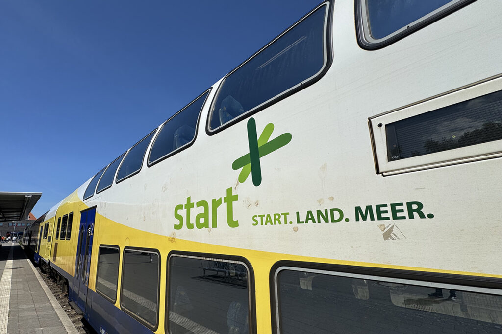 Ein Zug mit der Aufschrift Start steht an einem Bahnsteig.