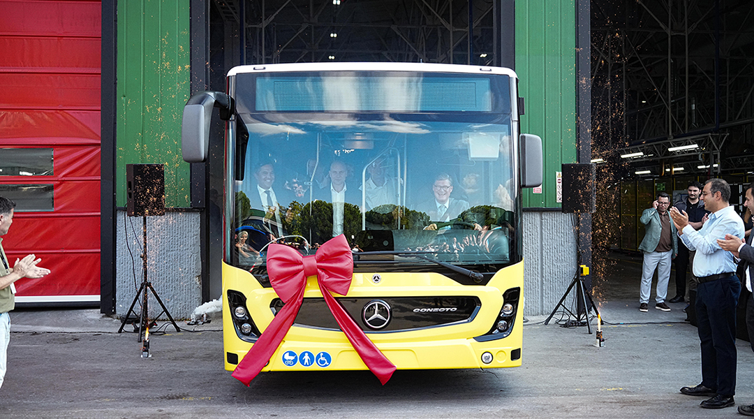 Ein Bus fährt aus einer Halle, Personen applaudieren.