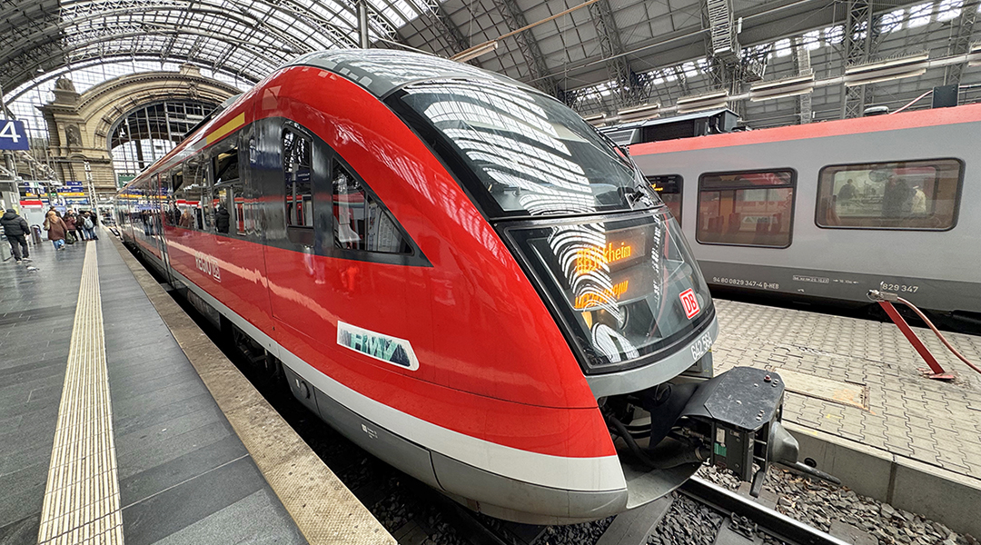 Ein Triebzug steht an einem Bahnsteig in einer Bahnhofshalle.
