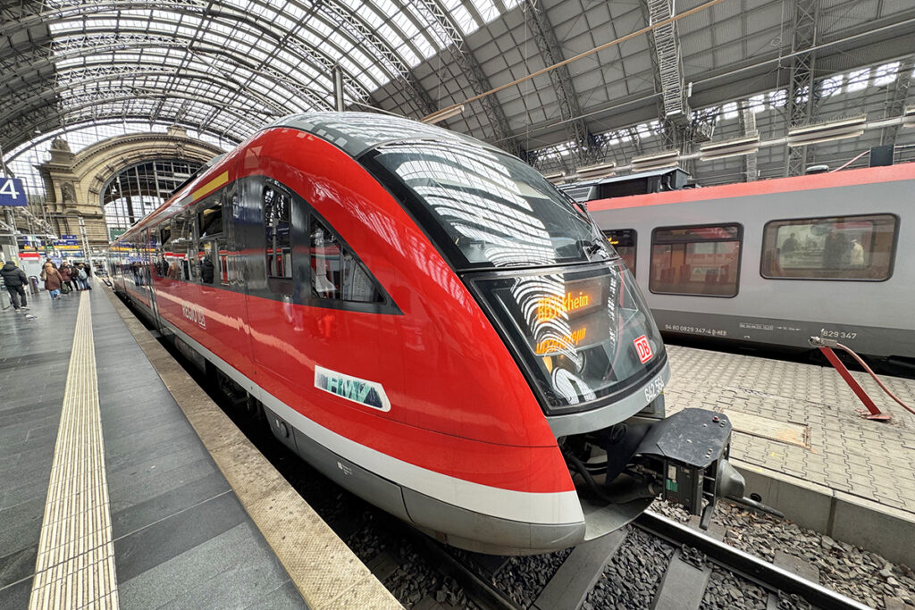 Ein Triebzug steht an einem Bahnsteig in einer Bahnhofshalle.