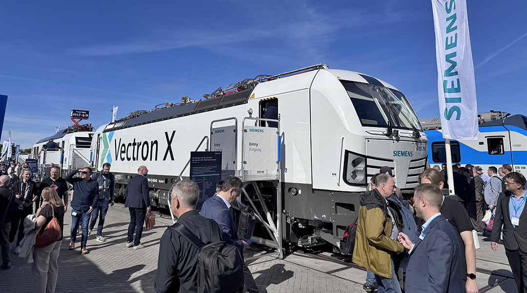 Vor zwei Siemens-Lokomotiven befinden sich viele Personen.