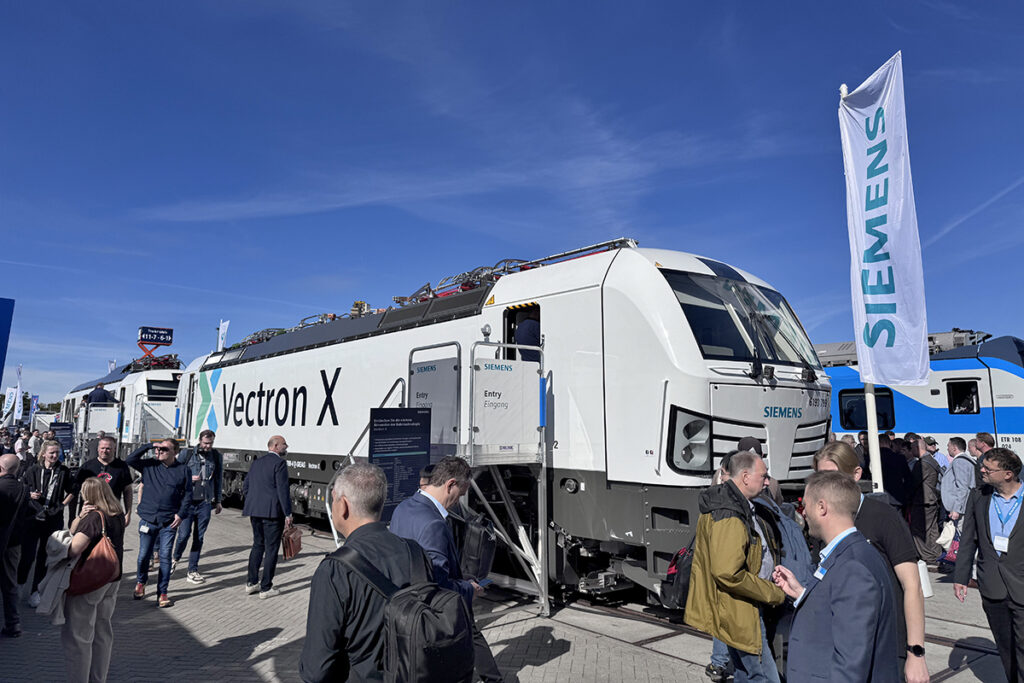 Vor zwei Siemens-Lokomotiven befinden sich viele Personen.
