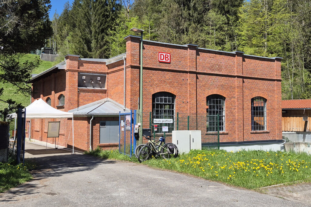 Das Gebäude eines Kraftwerks steht vor Bäumen.