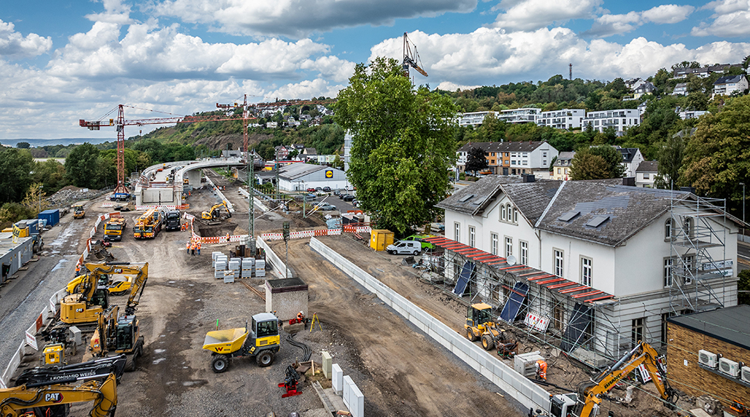 Luftaufnahme eines Bahnhofs, in dem die Gleise fehlen und in dem gebaut wird.
