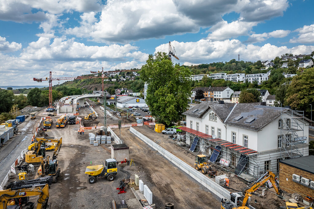 Luftaufnahme eines Bahnhofs, in dem die Gleise fehlen und in dem gebaut wird.