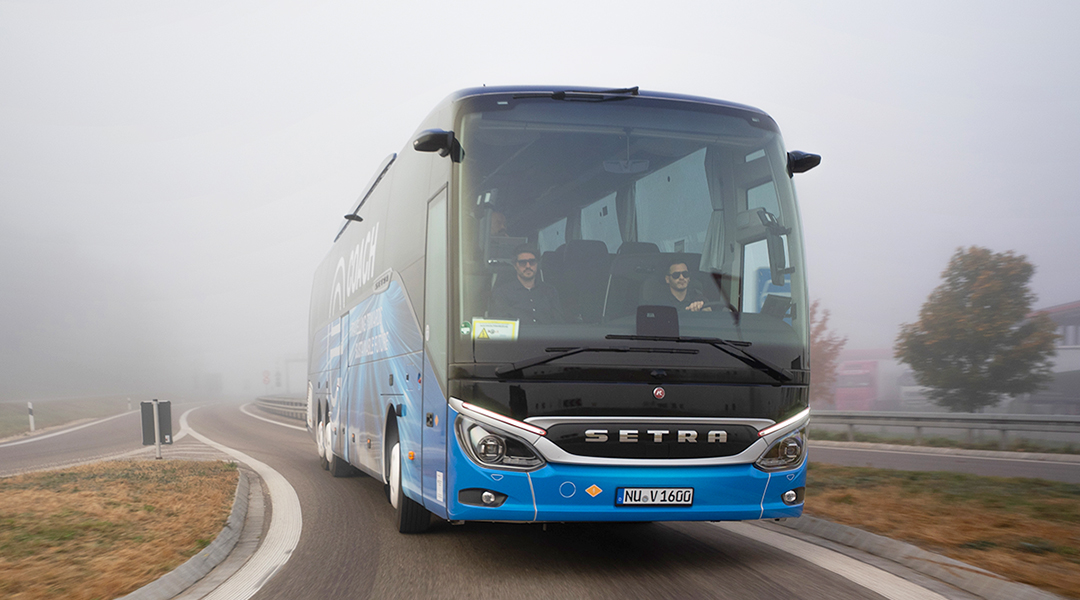 Ein elektrischer Reisebus fährt auf einer Straße.