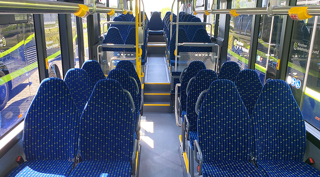 Blick in den Innenraum eines Linienbusses mit vielen Sitzen.