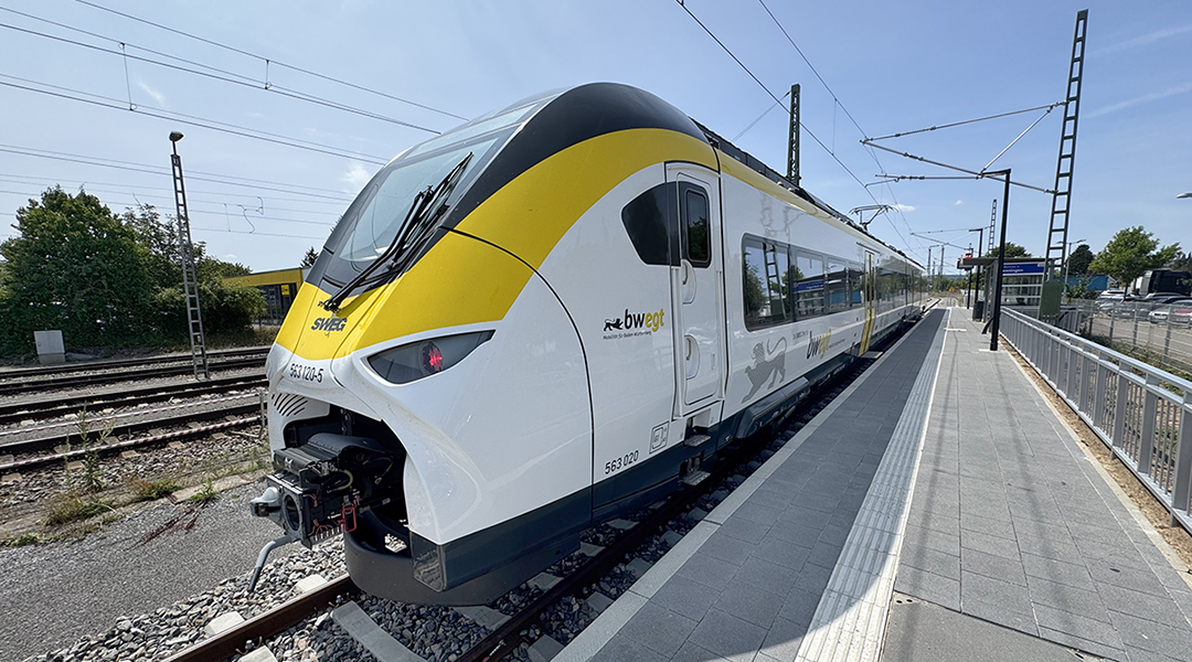 Ein Triebzug steht an einem Bahnsteig.