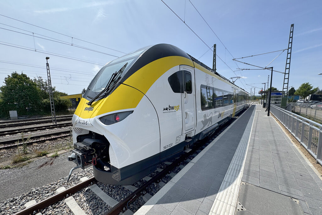 Ein Triebzug steht an einem Bahnsteig.