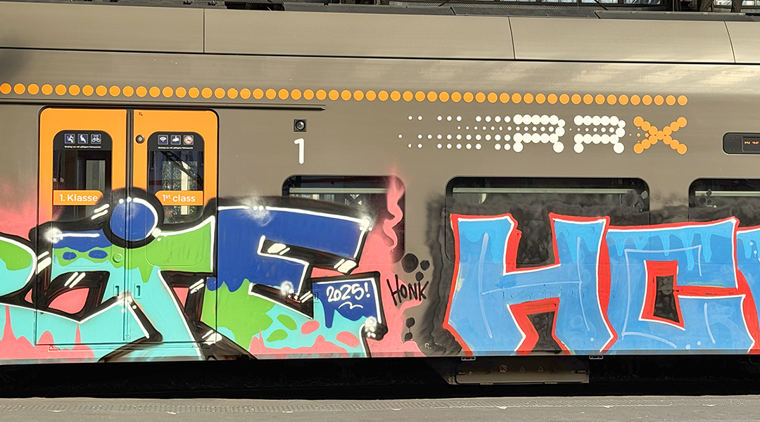 Die Seite eines Zuges ist mit Graffiti bemalt.
