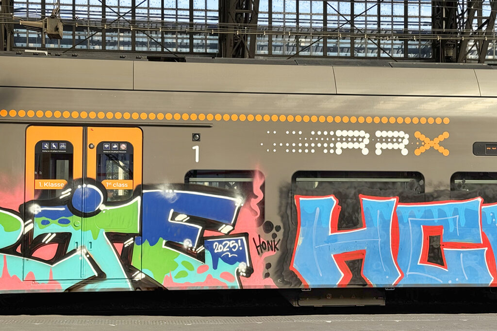 Die Seite eines Zuges ist mit Graffiti bemalt.
