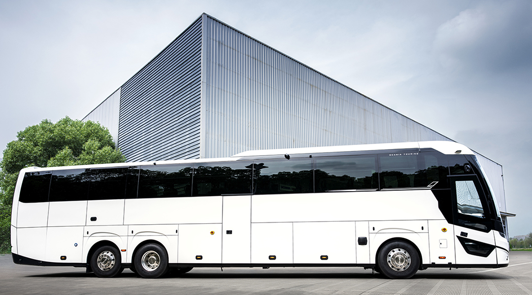 Ein Reisebus steht vor einem eckigen Gebäude.