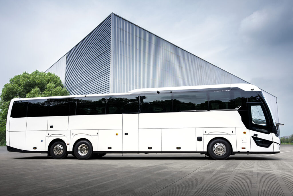 Ein Reisebus steht vor einem eckigen Gebäude.