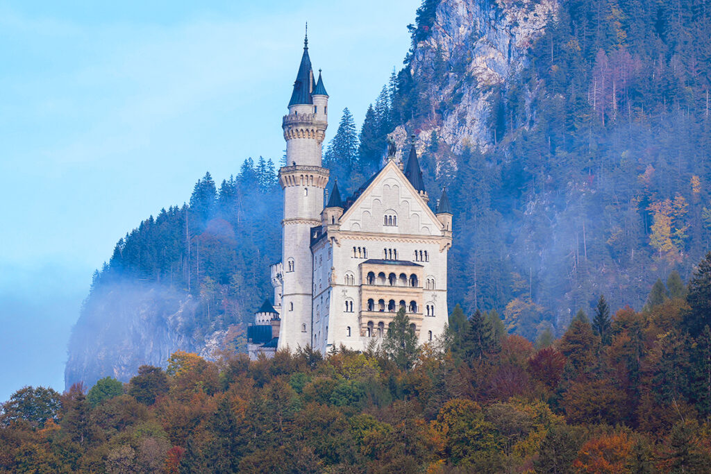 Blick auf Schloss Neuschwanstein mit einer Felswand im Hintergrund.