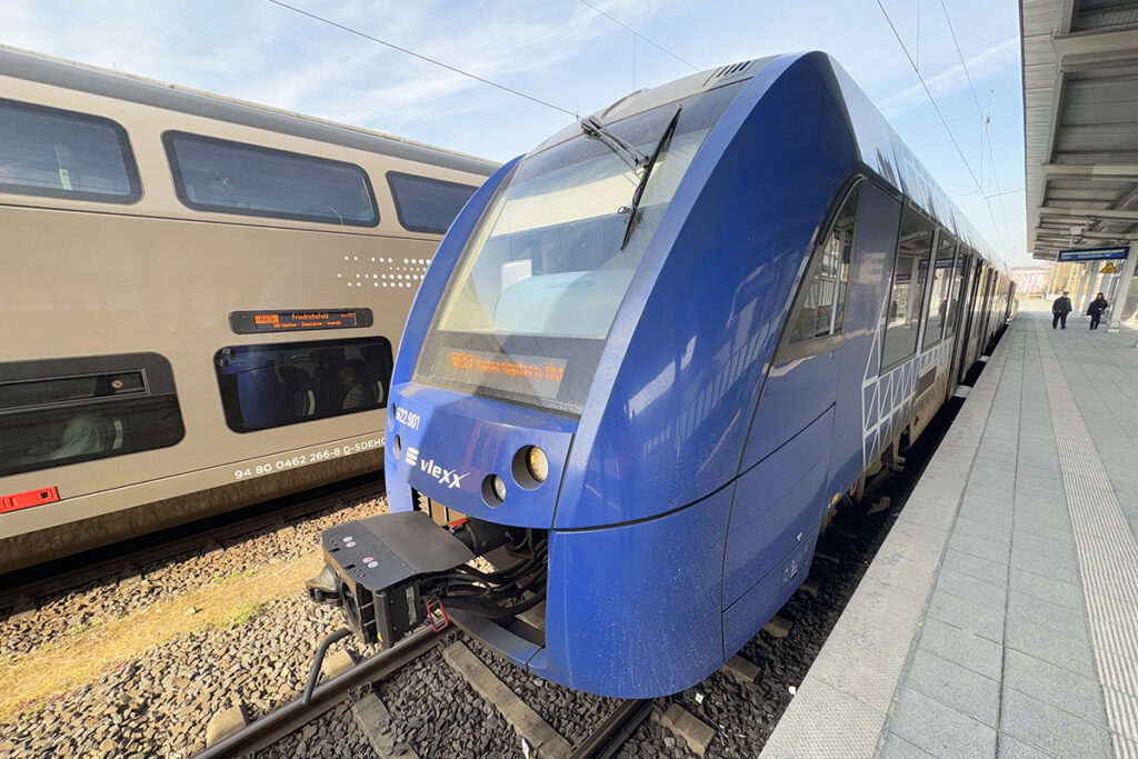 Ein Triebzug steht an einem überdachten Bahnsteig.
